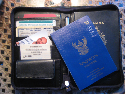 Passport (duh), work permit, tax ID card, 10 or 15 4x6 passport photos (plus some smaller ones that you can't see), birth certificate, other random ID (in this case, Canadian health care card), business cards, pen. I also have on hand photocopies of: main page and visa page of my passport, work permit, tax ID card and birth certificate. If any immigration official in the world requests an additional form of ID, about the only thing I can do is donate DNA.