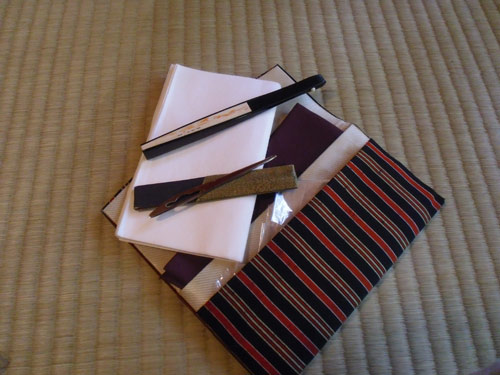 The kit that each guest uses. A fan (top), a small knife for cutting tea cakes, and paper napkins to place your cake on