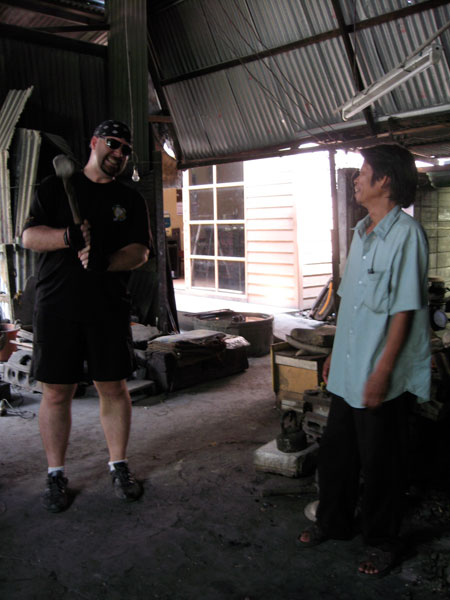 Me lifting one of the hammers that were even heavier than I expected them to be. On the right is one of the factory workers who smelled like a whiskey factory. In his defense, it WAS after noon. Barely.